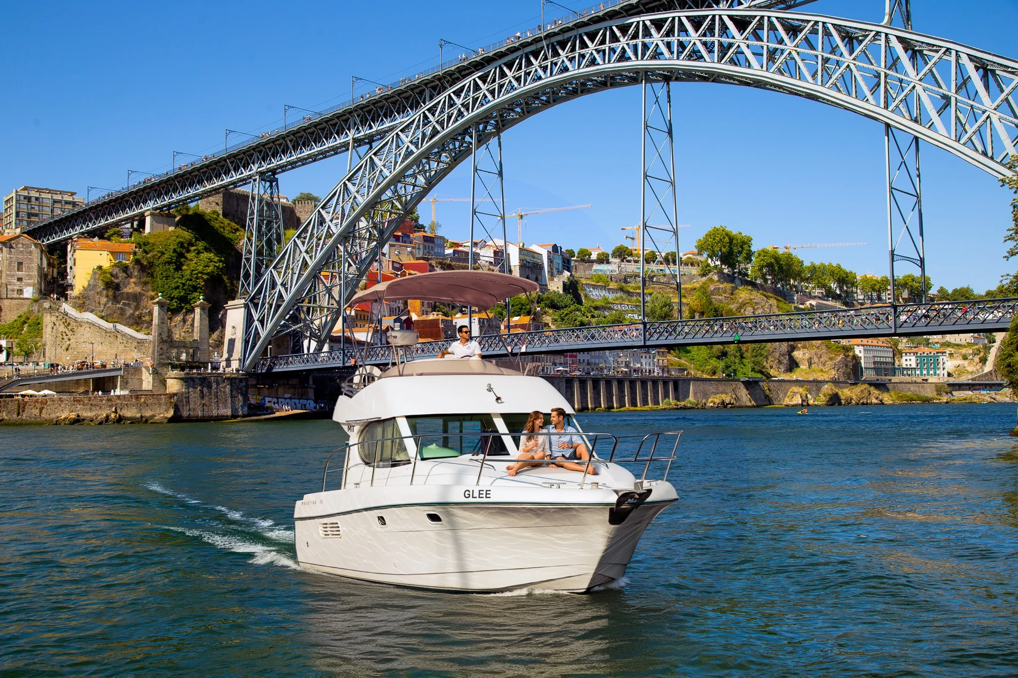 GLEE yacht cruising beneath Dom Luís I Bridge in Porto
